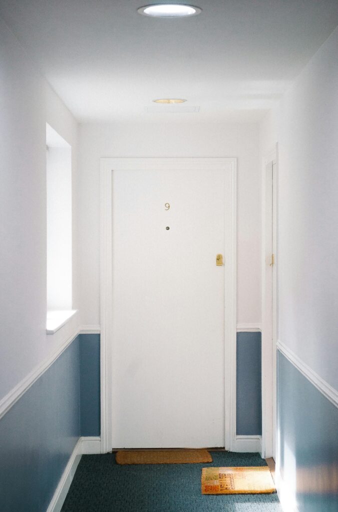 Bright minimalist hallway with door number 9 in a London apartment, capturing simple elegance.